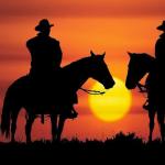 Cowboys riding off into the sunset together