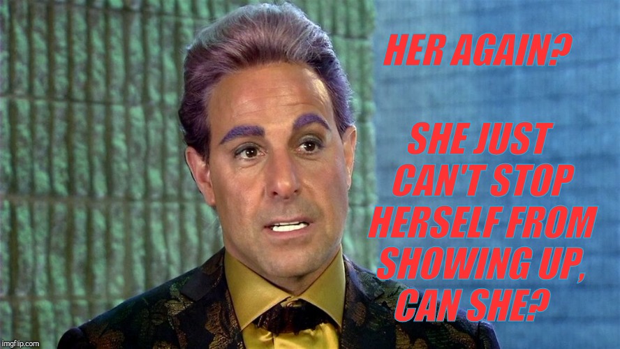 Hunger Games - Caesar Flickerman (Stanley Tucci) | SHE JUST CAN'T STOP HERSELF FROM SHOWING UP,  CAN SHE? HER AGAIN? | image tagged in hunger games - caesar flickerman stanley tucci | made w/ Imgflip meme maker