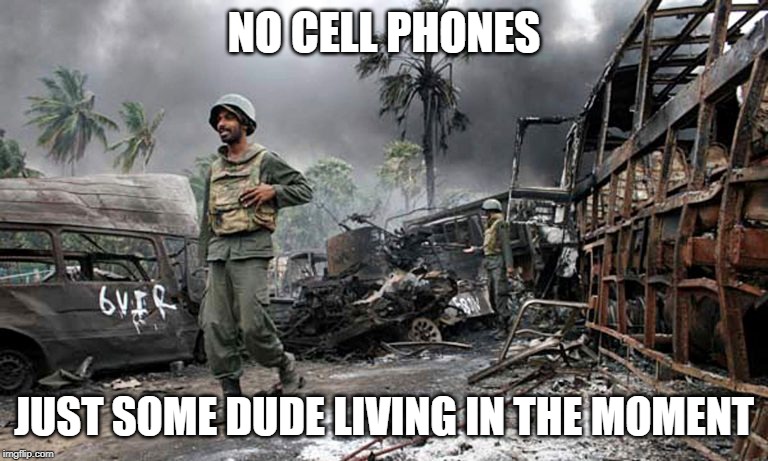Happy dude in war zone | NO CELL PHONES; JUST SOME DUDE LIVING IN THE MOMENT | image tagged in happy dude in war zone | made w/ Imgflip meme maker