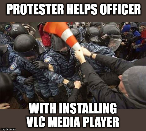 at first the image will be blurry | PROTESTER HELPS OFFICER; WITH INSTALLING VLC MEDIA PLAYER | image tagged in vlc,protesters,riot | made w/ Imgflip meme maker