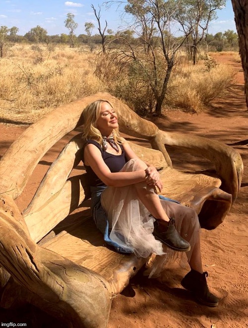 Kylie chillin’ on a curiously sculpted bench in the middle of nowhere. | image tagged in kylie outback 2,tourism,australia,celebrity | made w/ Imgflip meme maker