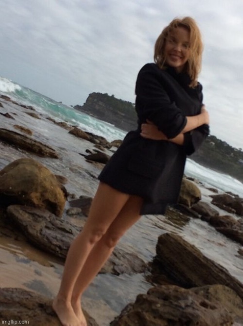 On a rocky beach in probably Australia | image tagged in kylie beach,beach,australia,meanwhile in australia,sweater,cute girl | made w/ Imgflip meme maker