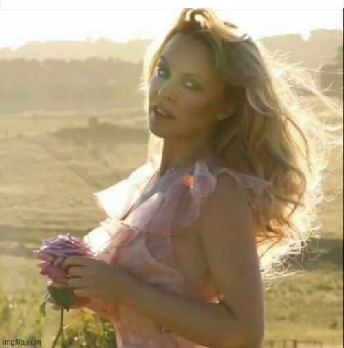 Gorgeous one in a field holding a flower. | image tagged in kylie flower,field,gorgeous,beautiful woman,beautiful,photography | made w/ Imgflip meme maker
