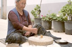 Woman using a hand-powered stone grist mill Meme Template