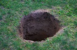 Deep Dirt Hole In Ground Or Lawn Stock Photo - Download Image No Meme Template