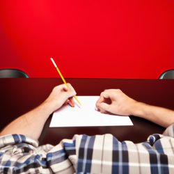 Person sitting at a desk with papers holding pencil Meme Template