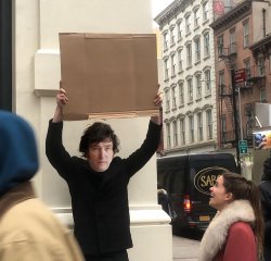 Javier Milei holding a cardboard sign Meme Template