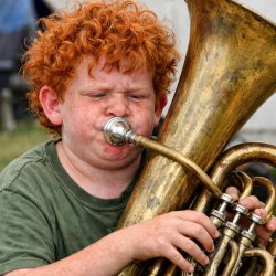 ugly red headed curly haired boy playing the tuba Meme Template