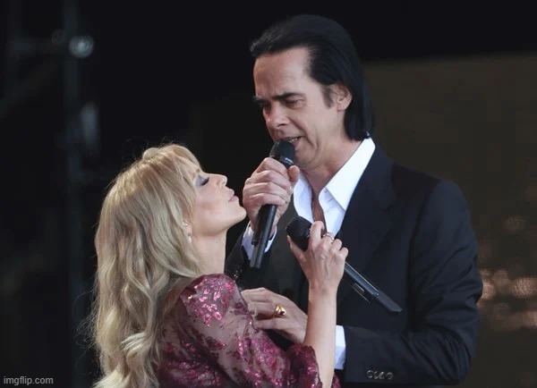Kylie & Nick Cave at Glastonbury 2019. Cringing at the rotten Covid-19 situation this year that's cancelled concerts. | image tagged in kylie minogue nick cave,singers,singer,covid-19,coronavirus,performance | made w/ Imgflip meme maker