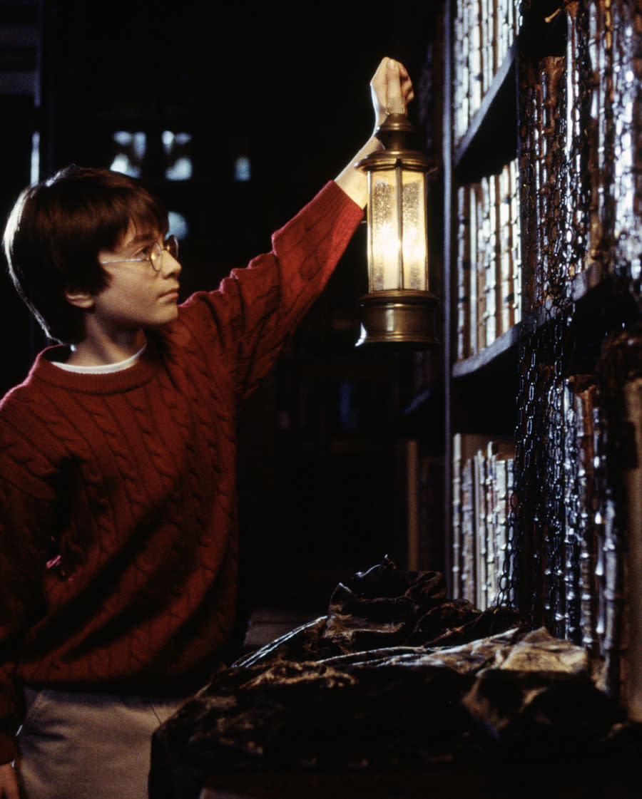 Harry Potter holding lantern up to bookshelf Blank Meme Template