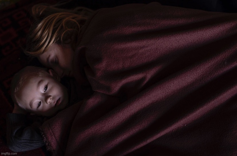 A mother and son sleep in a family area while waiting to board a train to Poland on March 12, 2022 in Lviv, Ukraine. | image tagged in ukrainian refugees,ukraine,ukrainian lives matter,ukrainian,refugees,refugee | made w/ Imgflip meme maker