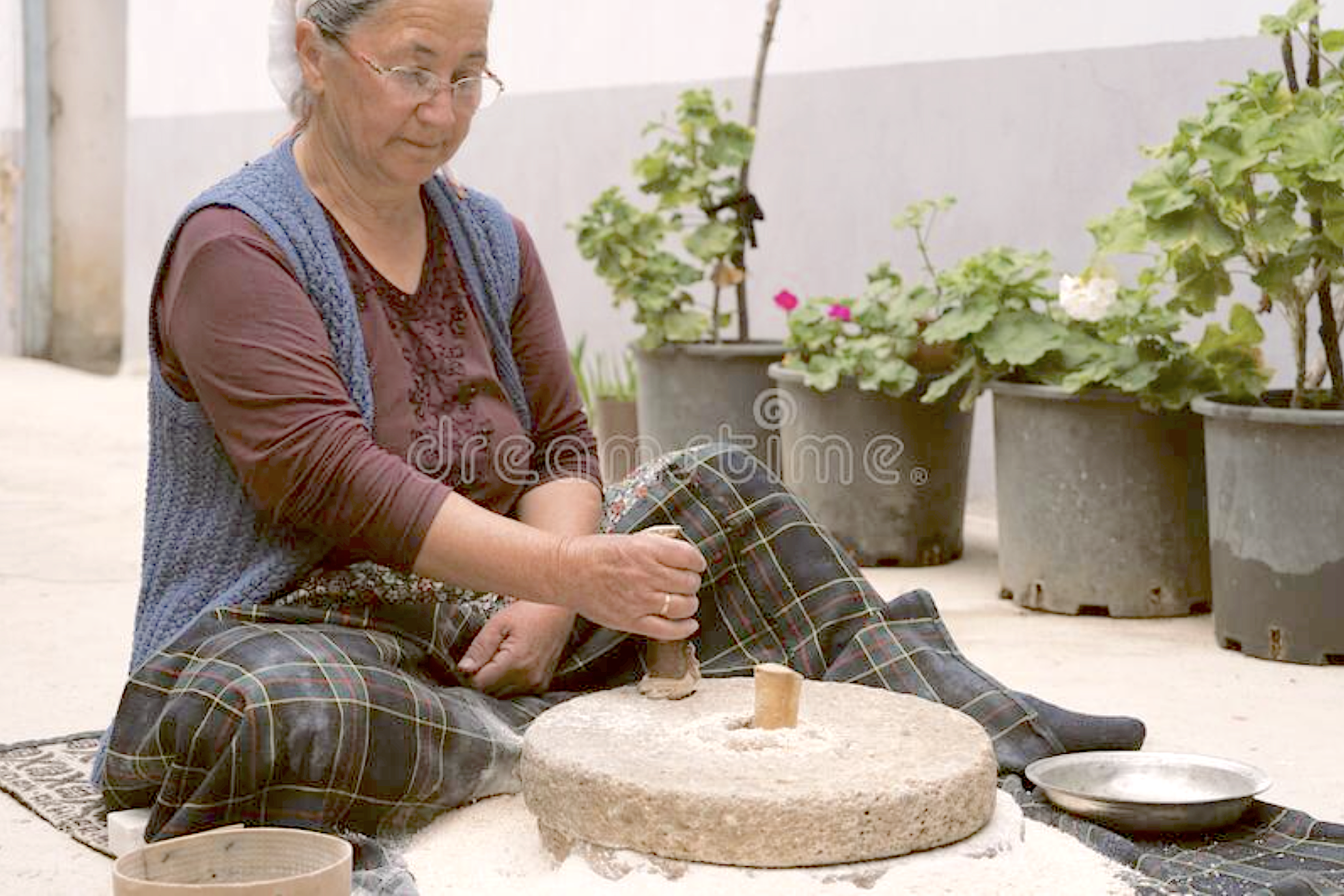 Woman using a hand-powered stone grist mill Blank Meme Template