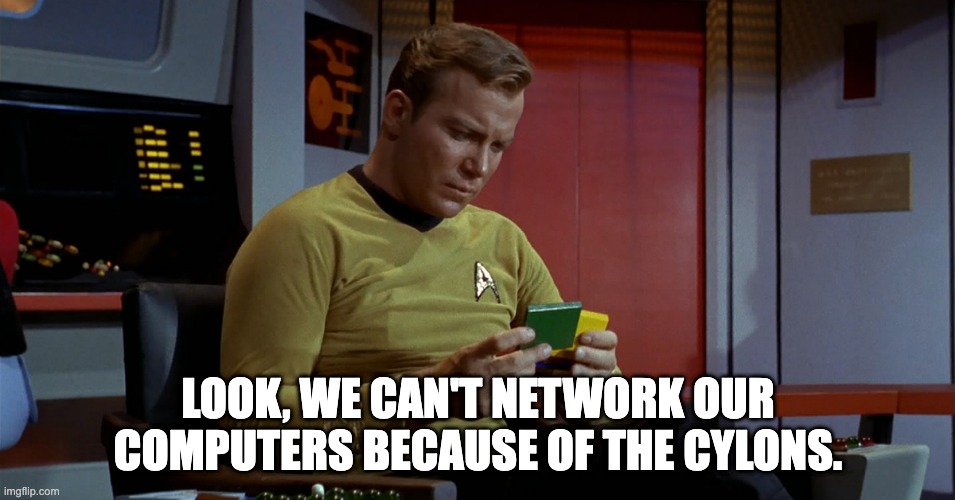 Kirk: Look we can't network our computers because of the Cylons. | LOOK, WE CAN'T NETWORK OUR COMPUTERS BECAUSE OF THE CYLONS. | image tagged in kirk looking at disks | made w/ Imgflip meme maker