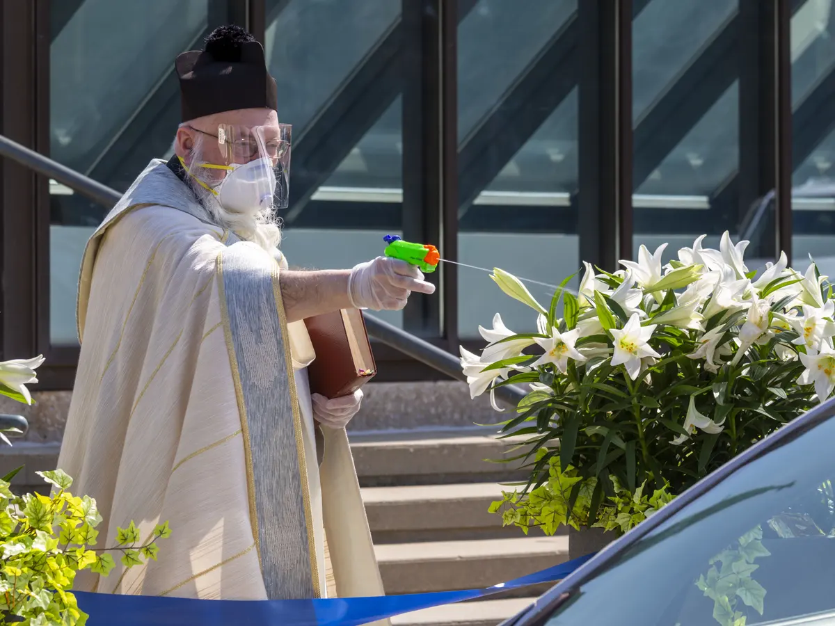 Priest spraying holy water doing safe distance Blank Meme Template