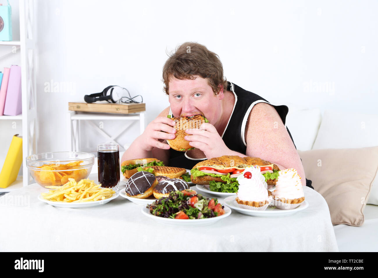 Fat man eating a lot of unhealthy food, on home interior backgro Blank Meme Template
