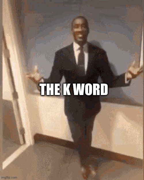 smiling black guy in suit | THE K WORD | image tagged in smiling black guy in suit | made w/ Imgflip meme maker