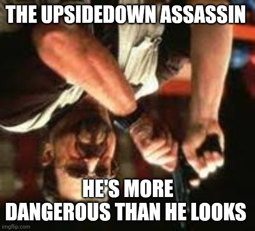 Upsidedown assassin | THE UPSIDEDOWN ASSASSIN; HE'S MORE DANGEROUS THAN HE LOOKS | image tagged in man loading gun | made w/ Imgflip meme maker