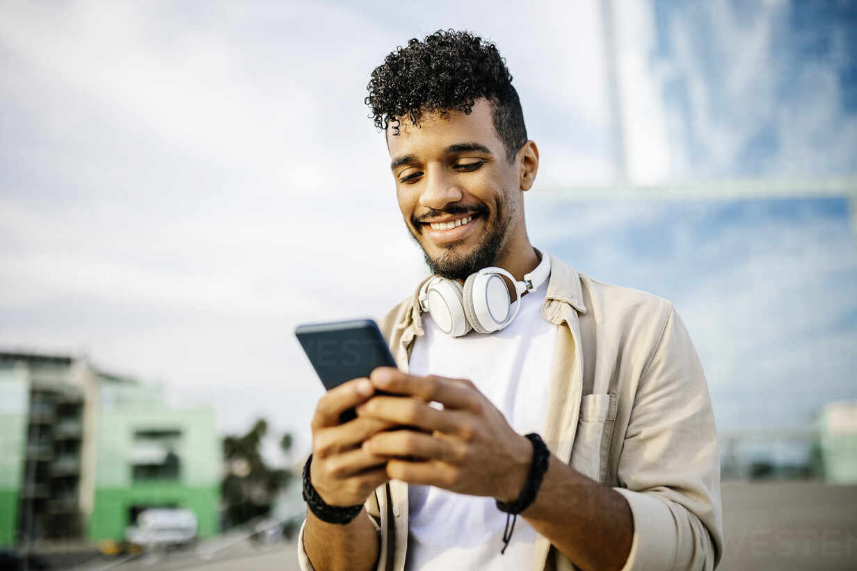 Happy man with headphones using smart phone stock photo Blank Meme Template