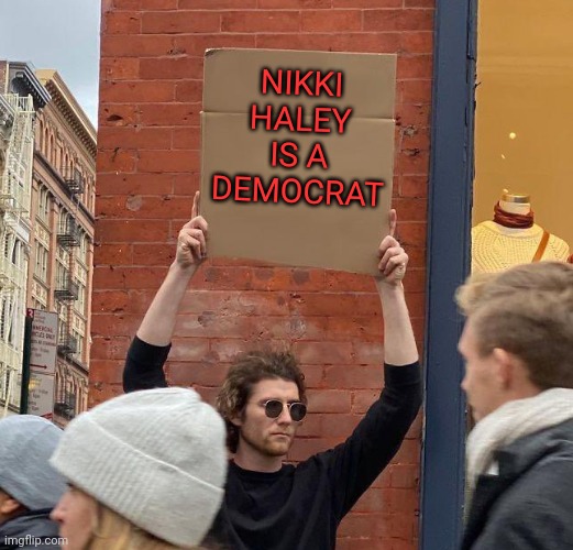 SHE'S WORKING FOR THEM | NIKKI HALEY IS A DEMOCRAT | image tagged in man with sign,nikki haley,democrat,politics | made w/ Imgflip meme maker