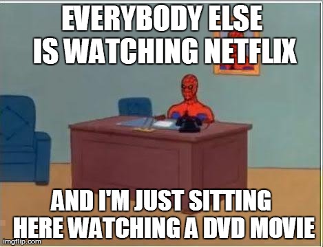 Spiderman Computer Desk Meme | EVERYBODY ELSE IS WATCHING NETFLIX AND I'M JUST SITTING HERE WATCHING A DVD MOVIE | image tagged in memes,spiderman | made w/ Imgflip meme maker