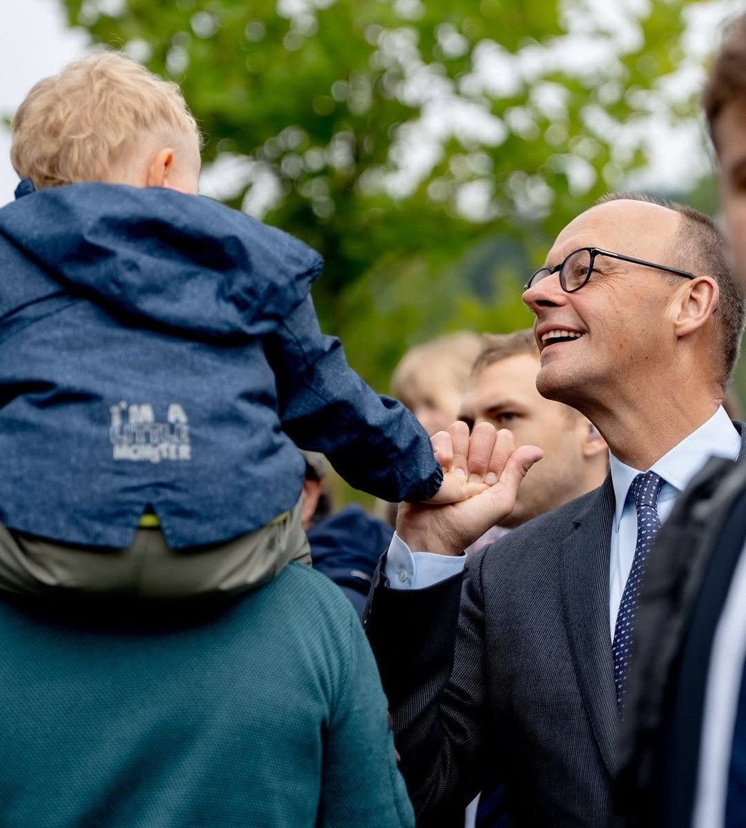 german Chancellor merz is talking to a toddler Blank Meme Template