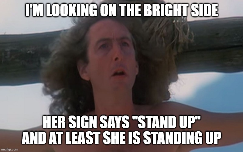 Always look on the bright side of life | I'M LOOKING ON THE BRIGHT SIDE HER SIGN SAYS "STAND UP" AND AT LEAST SHE IS STANDING UP | image tagged in always look on the bright side of life | made w/ Imgflip meme maker
