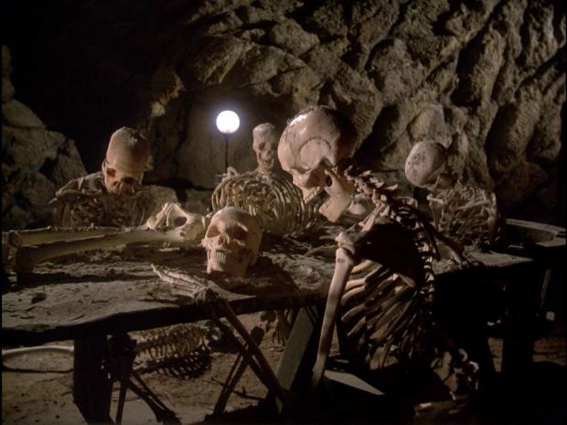 Skeletons waiting around a table Blank Meme Template